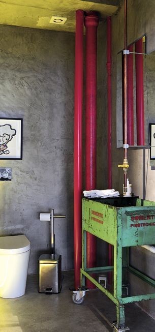 Decoração de tubos vermelhos na parede de um banheiro