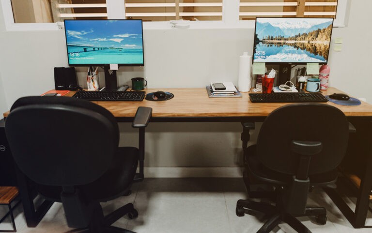 Escritório com mesa de madeira e parede branca
